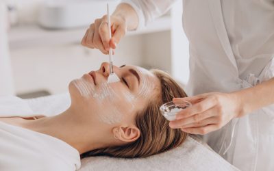 Cosmetologist doing face treatment and applying face mask